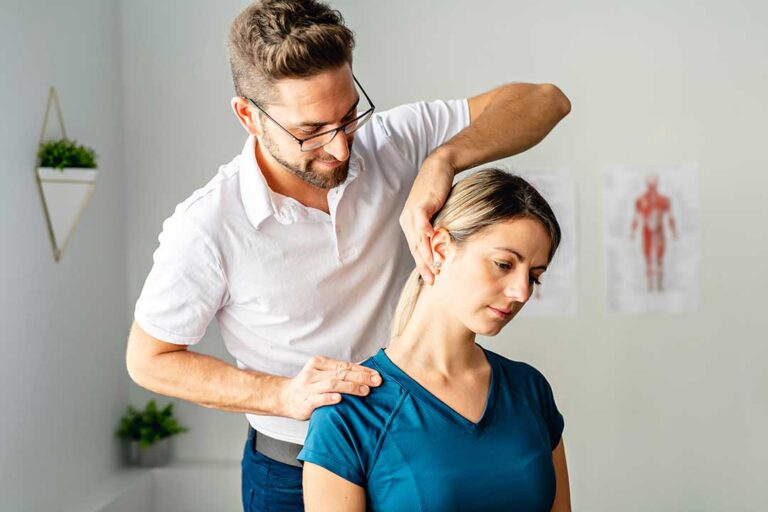 A person gently stretching their arm to the side with a neutral expression in a bright home setting.